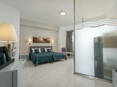 Camera d'albergo moderna con due letti, scrivania e lampade eleganti.