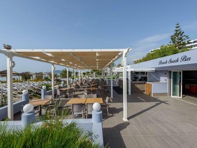 Area esterna con tavoli e sedie accanto a un ristorante dell'hotel sotto cielo sereno.