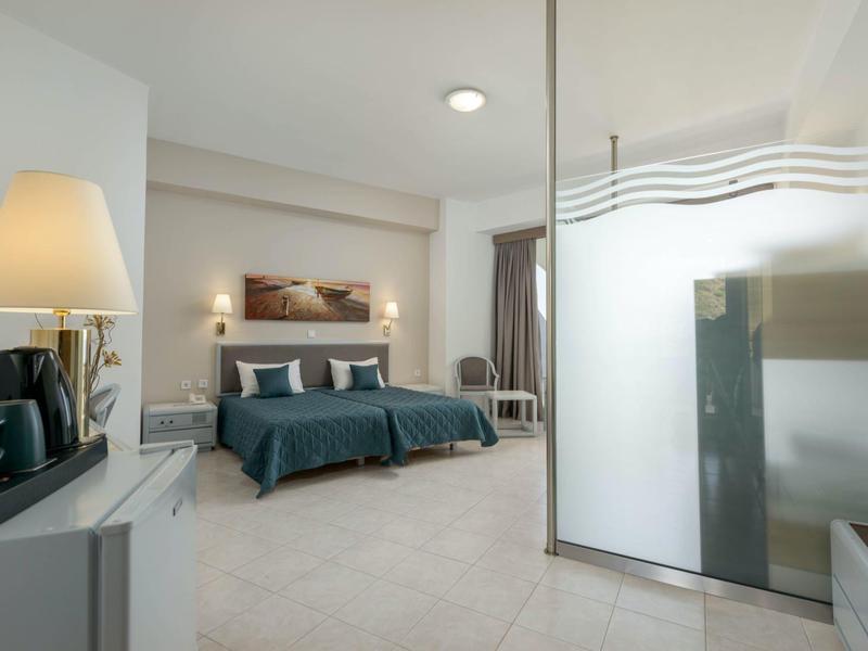 Camera d'albergo moderna con due letti, scrivania e lampade eleganti.