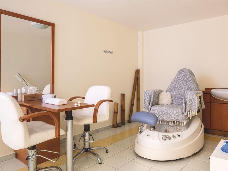 Interieur van een nagel- of schoonheidssalon met stoel, spiegel en pedicure apparaat.