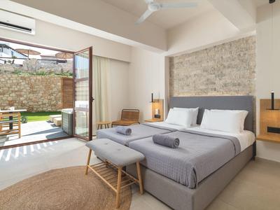 Modernes Schlafzimmer mit großem Fenster zur Terrasse, grauem Bett und natürlicher Steinwand.