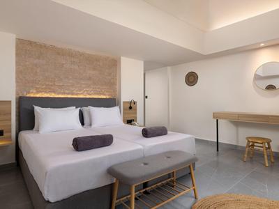 Modernes Schlafzimmer mit großem Bett, grauem Kopfteil und minimalistischen Holzmöbeln.