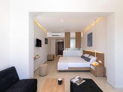Chambre d'hôtel moderne avec deux lits doubles et un coin canapé aux couleurs claires.