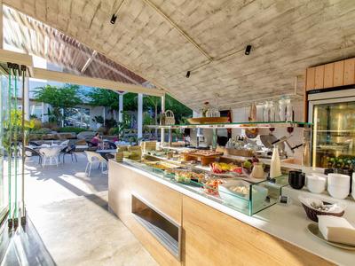 Eleganter Buffetbereich mit gedeckten Speisen, hellem Steinboden und Zugang zu sonniger Terrasse.
