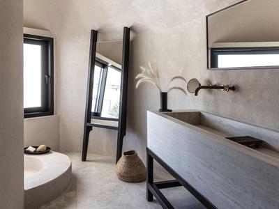 Modernes Badezimmer mit ovaler Wanne, großem Spiegel und Betonwaschtisch in hellem Raum.