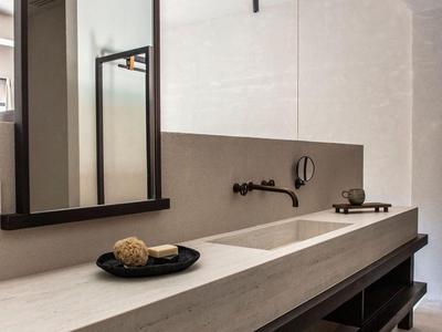 Moderner Hotelwaschtisch mit großem Spiegel, flachem Wasserhahn und gestreiftem Boden.
