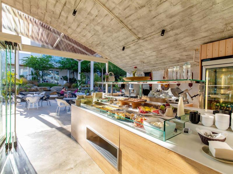 Buffet dell'hotel luminoso con piatti freschi e vista sulla terrazza soleggiata.