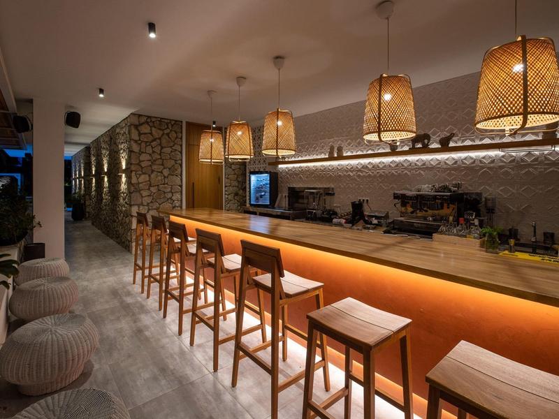 Bar dell'hotel moderna con sgabelli in legno e illuminazione calda.
