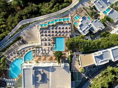 Vista aerea di un resort con diverse piscine, lettini e alberi