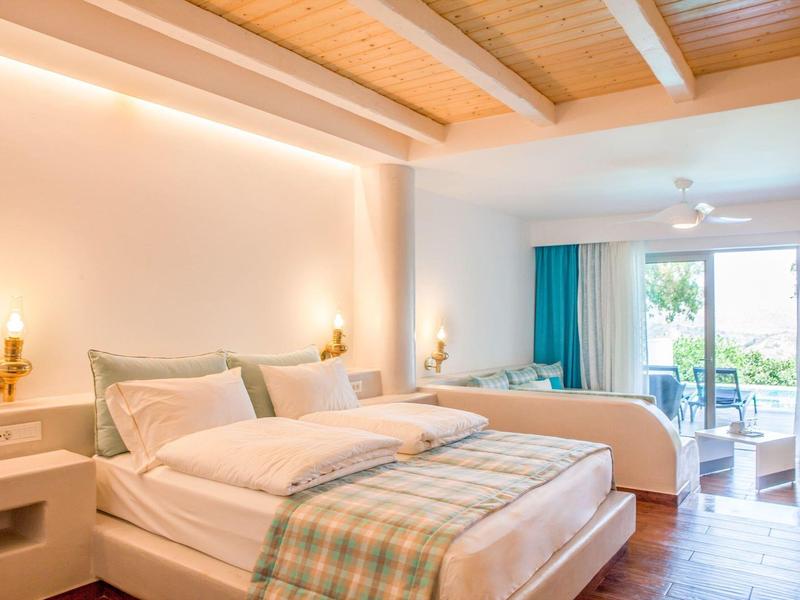 Camera matrimoniale luminosa con travi in legno e balcone in hotel