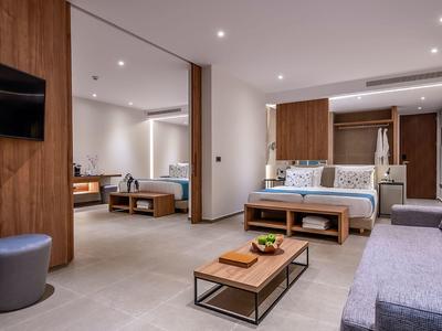 Area della camera d'hotel moderna e aperta con posti a sedere e accenti in legno.