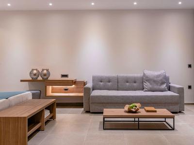 Zona giorno moderna con divano grigio, tavolo in legno e decorazioni eleganti.