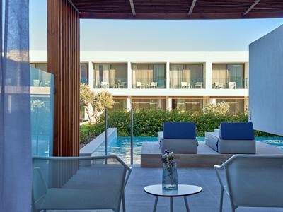 Balcone moderno dell'hotel con posti a sedere e vista sulla piscina e gli edifici bianchi