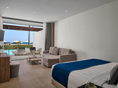 Camera d'hotel moderna con letto grande e vista sulla piscina e il mare