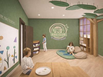 Kinderspielraum mit grünem Thema, Sitzkissen und Wanddekoration in einem Hotelzimmer.