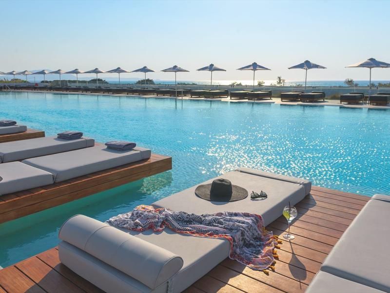 Piscina di lusso con lettini e ombrelloni vicino all'acqua, perfetta per rilassarsi.