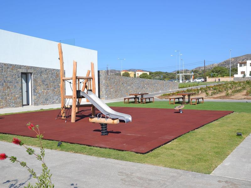 Un cestino di croissant e un bicchiere di succo d'arancia su un tavolo all'aperto con sfondo sfocato.