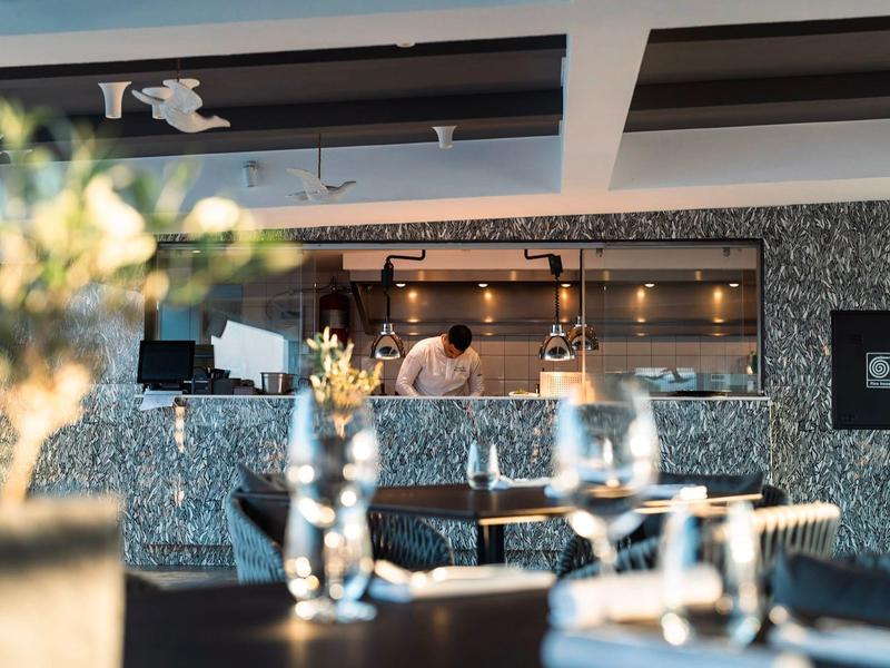 Area bar moderna con pareti a mosaico e bicchieri scintillanti in hotel elegante.