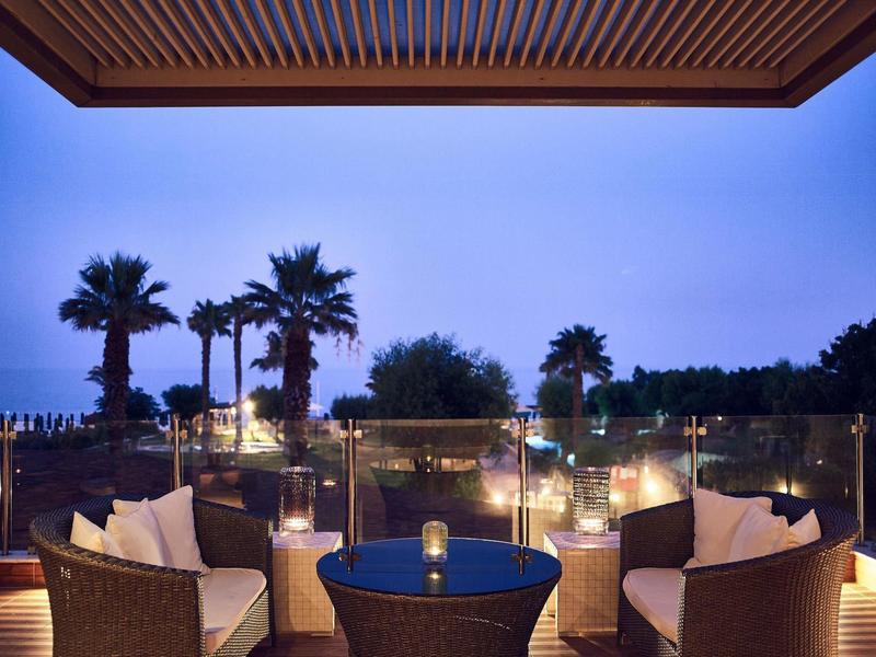 Comodi posti a sedere all'aperto con vista su palme e cielo serale in un hotel.