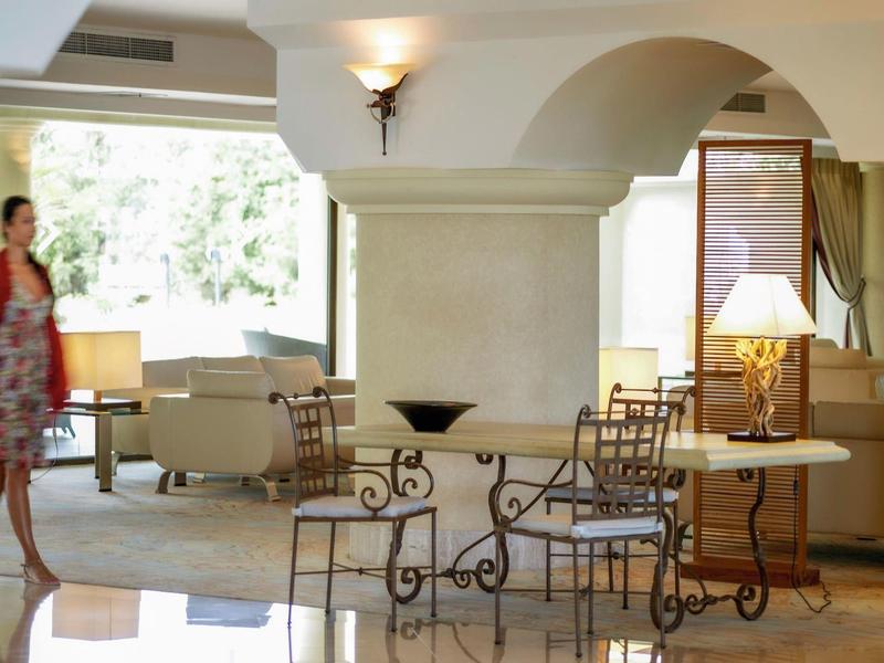 Hall dell'hotel ben illuminato con area salotto e mobili decorativi