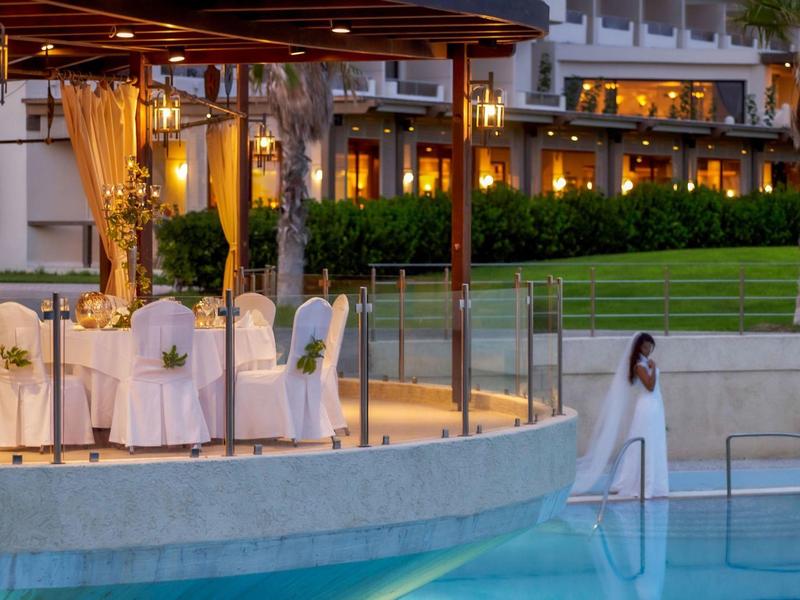 Area esterna elegante con tavoli apparecchiati e piscina in un hotel