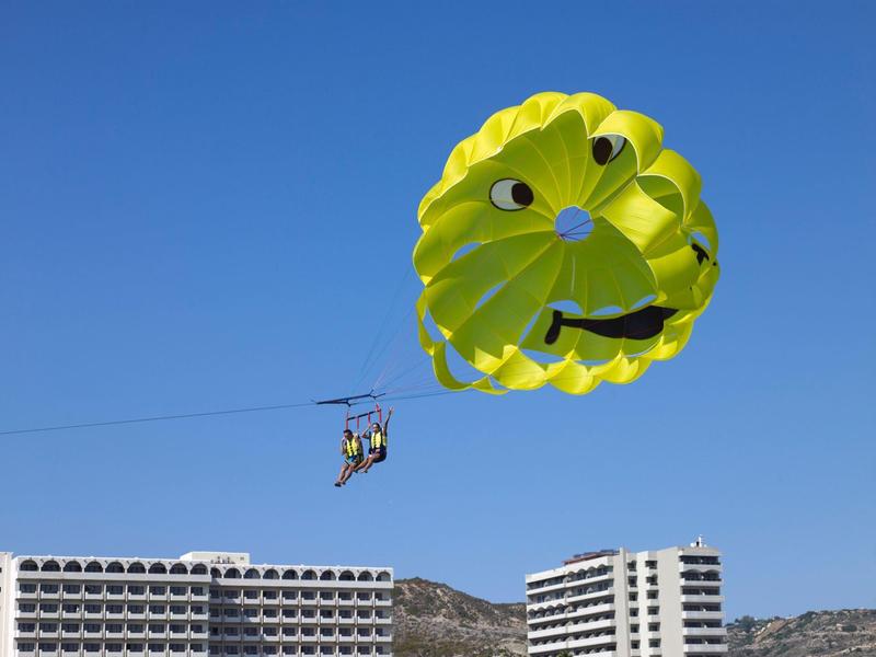 Torre rotonda accanto alla piscina con vista sul mare e palme in località turistica.
