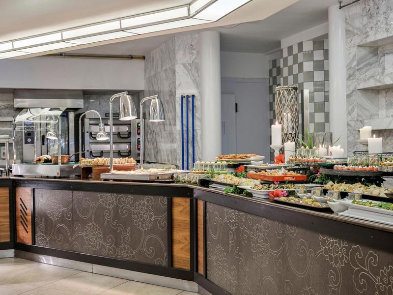 Buffet con piatti vari in un atrio d'hotel moderno decorato con eleganza.