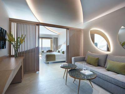 Lounge d'hotel moderno con divano curvo, specchi rotondi e illuminazione d'ambiente.