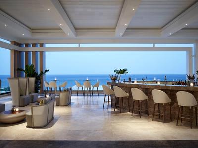 Bar moderno all'aperto con vista mare, sgabelli in vimini e area salotto accogliente sotto travi.