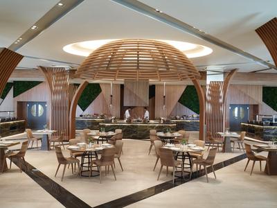 Area ristorante moderna con tavoli rotondi in legno e elemento centrale a cupola in legno.