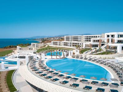 Grande resort alberghiero con piscine e vista sul mare sotto un cielo azzurro limpido