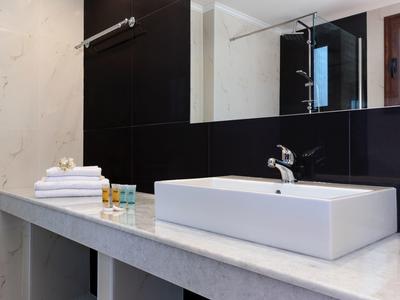 Moderner Badezimmerspiegel mit weißem rechteckigem Waschbecken und grauer Marmorarbeitsplatte.