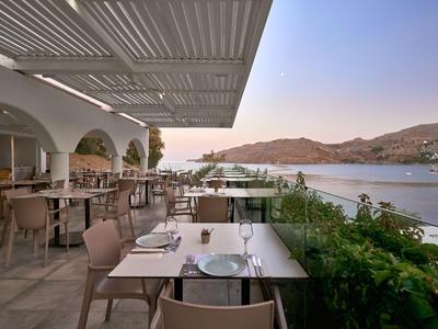 Restaurant ouvert avec vue sur la mer et les montagnes au coucher du soleil