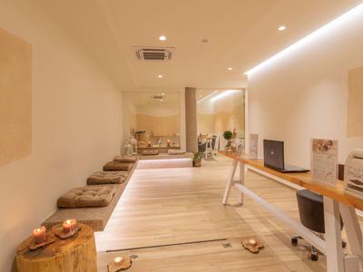 Heller, moderner Meditationsraum mit Kissen, Holzboden, Kerzen und minimalistischer Einrichtung.