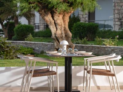 Tavolo con due sedie accanto a un albero davanti a un edificio dell'hotel.