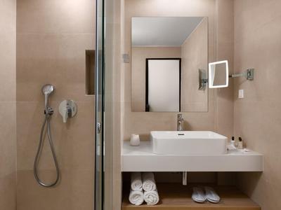 Moderne badkamer met wastafel, spiegel, handdoeken en inloopdouche.