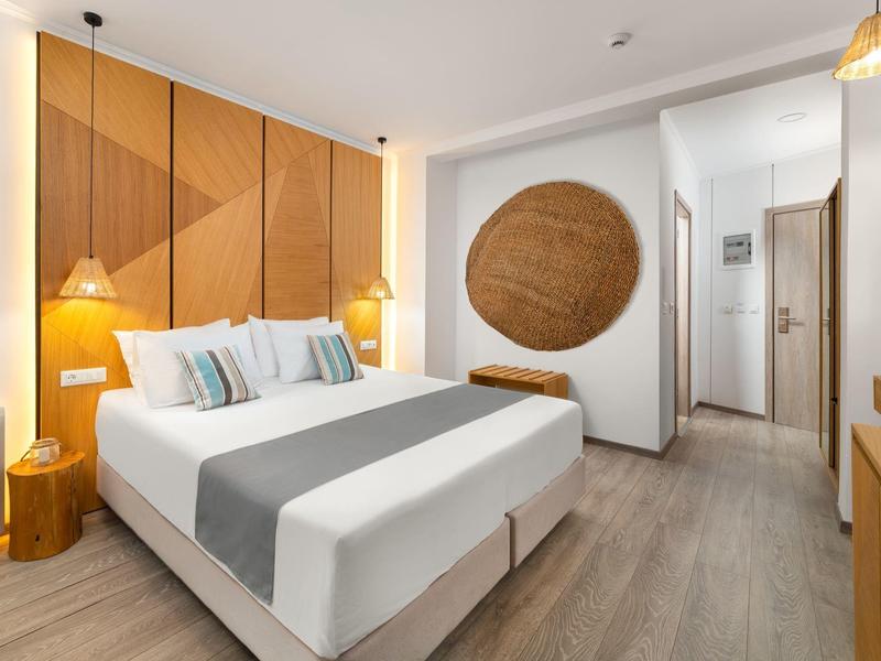 Moderne hotelkamer met een tweepersoonsbed, houten accenten en zacht licht.