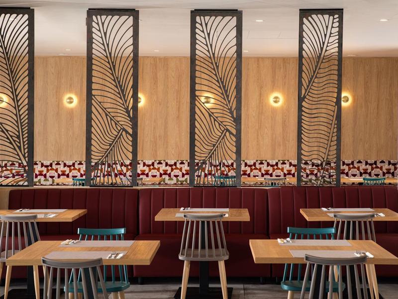 Moderne eetruimte met houten lambrisering, decoratieve scheidingswanden en stijlvolle stoelen.