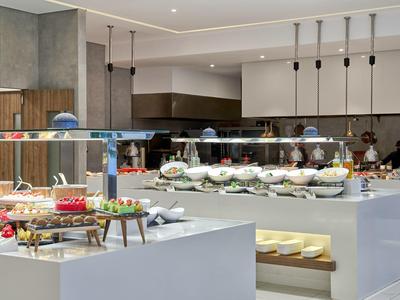 Buffet moderno in hotel con piatti diversi e bancone bianco minimalista.