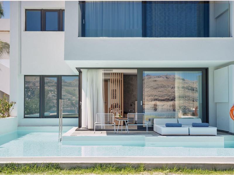 Edificio di hotel moderno con piscina e area salotto sulla terrazza.