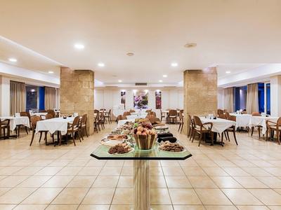 Comedor moderno y luminoso con mesas puestas y buffet central.