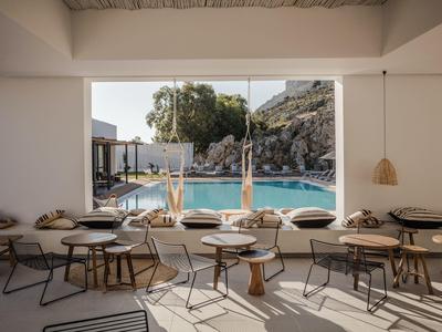 Interno moderno e luminoso con vista su piscina e paesaggio montano.