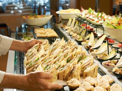 Buffet avec une variété de sandwiches et d'entrées servi dans un cadre hôtelier ou restaurant.