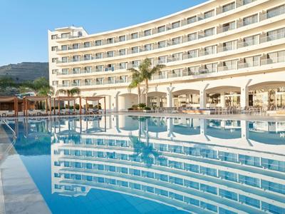 Moderner Hotelkomplex mit geschwungenem Aufbau und großem Außenpool bei Tageslicht.