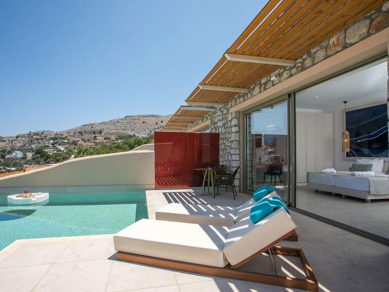 Terrasse moderne avec piscine, chaises longues et vue sur collines et ville.