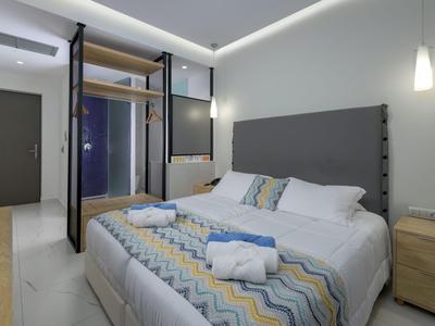 Habitación de hotel moderna con cama grande, mesita de noche y diseño minimalista.