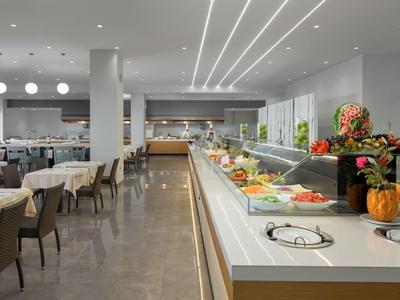 Espacio moderno de restaurante con área de buffet luminosa y mesas preparadas.