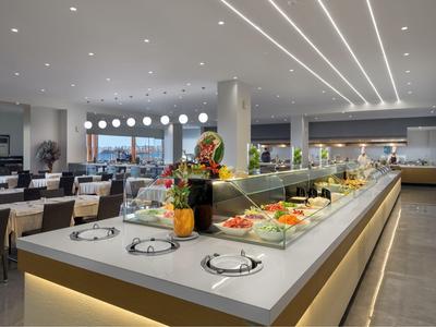 Área de comedor luminosa con un gran buffet y luz moderna en un hotel.