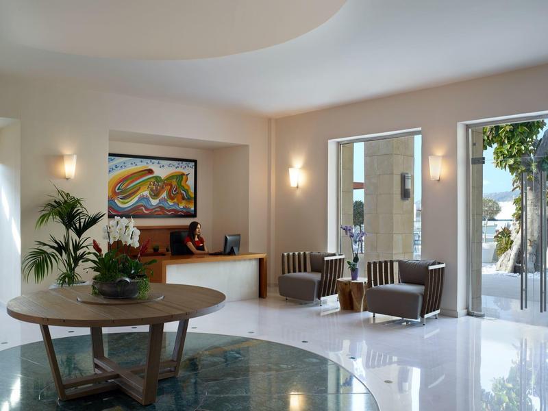 Bright hotel lobby area with round tables, chairs, and modern decor.