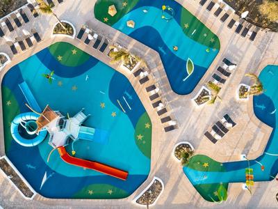 Aerial view of a modern water park with multiple pools, slides, and lounge chairs.
